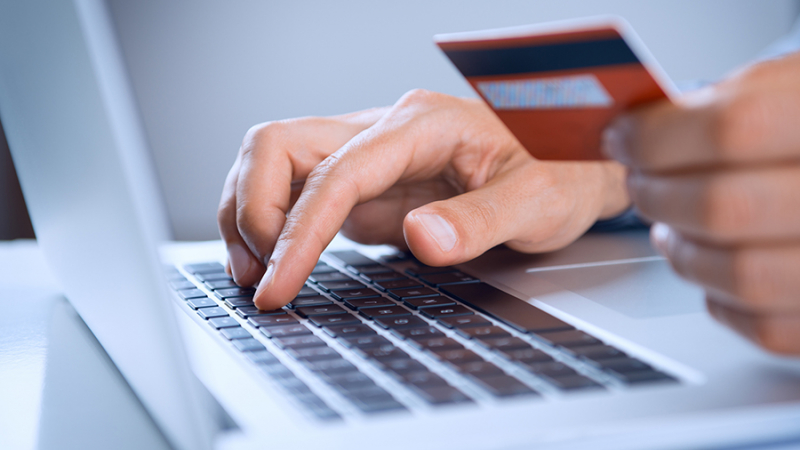 Close Up Of A Man Shopping Online Using Laptop With Credit Card
